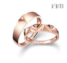 two rose gold wedding rings with diamonds on each side and the word love written in white lettering