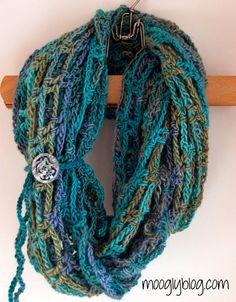 a blue and green scarf hanging on a wooden hanger