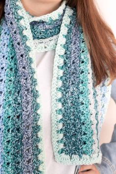 a woman wearing a blue and white crocheted scarf