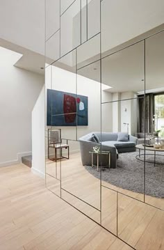 a living room filled with furniture and mirrors reflecting it's interior walls in the mirror