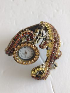 Jessica Carlyle Watch Vintage Rhinestone Lizard Watch Wrist Size: 7.5 inches Condition: Very good This Item Comes From a 100% Smoke-Free Home  All Items are Carefully Inspected Prior To Listing and Prior To Shipping This Item is Exactly as Described  Original photo of the item is used. Stones have not been tested and may be an imitation Gemstone where present, is not verified if it natural or synthetic.  Authenticity of Brand is not verified.  FREE shipping is only to US addresses  No guarantees as to the continued accuracy  Items are pre-owned and will not have the original box or paperwork  All quartz watches will have new batteries installed and in working condition unless otherwise stated in the description.  *Please note: item is used and being sold as is*  Will combine shipping for m Clock Ring Vintage, Rhinestone Watches With Round Dial, Rhinestone Watches Perfect As Gifts, Clock Ring, Photo Originale, Watch Vintage, Design Essentials, Original Photo, Women Wrist Watch