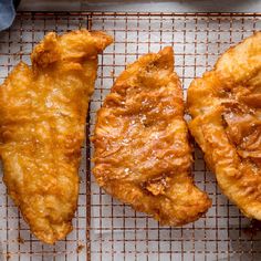 three pieces of fried food sitting on top of a cooling rack