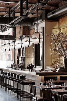 an empty restaurant with tables, chairs and chandeliers hanging from the ceiling above