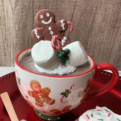 a cup filled with hot chocolate and marshmallows on top of a red tray