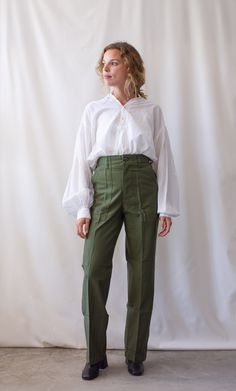 "These 80s army high waist pants feature the following: Straight slim leg, zipper fly, belt loops, two front flat pockets, two back flap pockets. PLEASE READ MEASUREMENTS CAREFULLY. These are best for petite figures. Maker: Military Made in the USA Material: 100% Cotton CONDITION: Excellent, These are all deadstock and have never been worn. Measurements: 25\" Waist / 13\" Rise / 34-35\" Hips NARROW / 11.5\" Thigh flat / 9\" Leg Opening / 30.5\" Inseam Ellie is 5'3\" and wears 0-00 in modern jean Army Fatigue, Army Pants, Slim Trousers, High Waist Pants, Waist Pants, Trouser Pants, Slim Legs, High Waisted Pants, Capri Pants