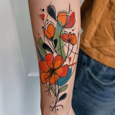 a woman's arm with an orange and green flower tattoo on the left forearm