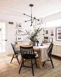 the dining room table is set with four black chairs and a white tablecloth on it