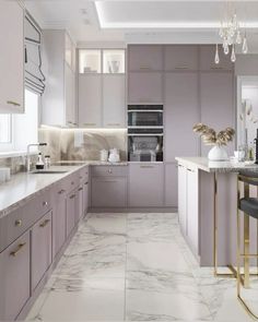 a kitchen with marble counter tops and purple cabinetry, along with gold trimmings