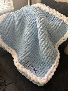 a blue and white blanket sitting on top of a couch