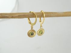 The gold-plated stainless steel hoop earrings have an outer diameter of approx. 12 mm. They are approx. 1 mm thick. They have a total length of approx. 2 cm. The 14K gold-plated stainless steel pendant has a diameter of approx. 8 mm and the zirconia cabochon is approx. 3 mm in size. The hoop earrings have a folding closure. The earrings come in a pretty jewelry box. In my shop you can find the chain as well as other hoop earrings in different sizes and colors. If you have other requests please contact me. **Used material** Stainless steel hoop earrings gold plated, stainless steel pendant 14K gold plated, cabochon zirconia **Size/Dimensions/Weight** see description/Very light **Production method** Made for you Please always note the information card that is included with every order. Stain Green Tarnish Resistant Huggie Earrings For Gifts, Green Gold Plated Round Earrings, Green 14k Gold Round Earrings, Green Gold-plated Hoop Jewelry, Gold-plated Gemstone Hoop Earrings Gift, Green Gold-plated Round Earrings, Green Gold-plated Tarnish-resistant Hoop Earrings, Green Tarnish-resistant Gold-plated Hoop Earrings, Green Peridot