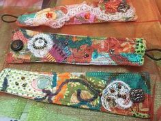 two colorful bracelets sitting on top of a table next to an orange cloth bag