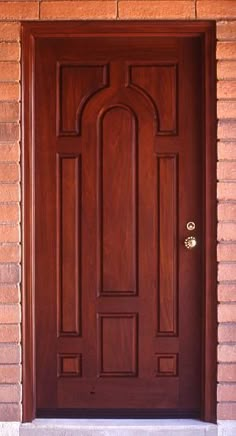 a close up of a wooden door on a brick building