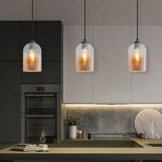 three lights hanging from the ceiling in a kitchen