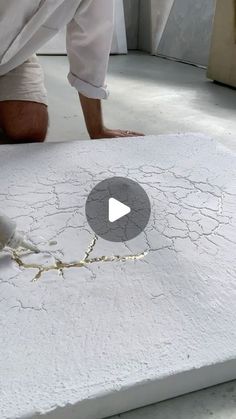 a man kneeling down on top of a white mattress