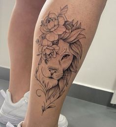 a woman's leg with a lion and flowers on it