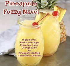 two glasses filled with pineapple fuzzy navel on top of a metal tray next to each other