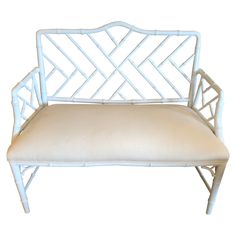 a white bench with a cushion on it