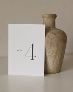 a card with the number four on it next to a vase