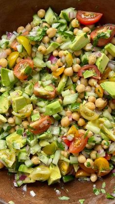 a wooden bowl filled with lots of vegetables