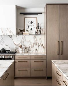 a kitchen with marble counter tops and wooden cabinetry, along with an art work on the wall