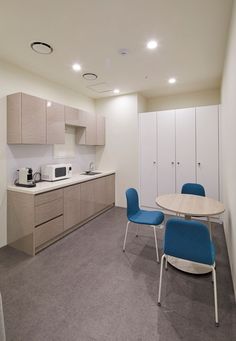 an empty kitchen and dining area with blue chairs