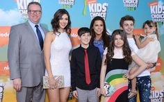 a group of people standing next to each other in front of a colorful wall with the words kids's choice written on it