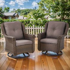 two wicker chairs sitting on top of a wooden floor next to a white picket fence