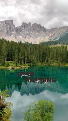 a lake surrounded by trees and mountains with the words good morning on it