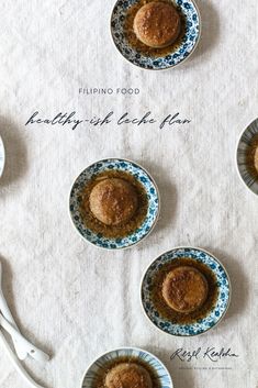 four small plates with food in them on top of a white table cloth next to utensils