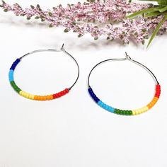 Show your pride with these colorful, lightweight hoop earrings! Hand-beaded with genuine Miyuki Preciosa Japanese glass seed beads, these earrings are available either fully beaded or partially beaded, as shown in the photos. Just list your preference in the personalization box at checkout.  The hoops are available in 3 different sizes as shown, from largest to smallest - if you are looking for a different size, send a message! - 35 mm (almost 1.5" diameter circle) - 25 mm (approximately 1 inch Lesbian Earrings, Pride Earrings, Pride Jewellery, Rainbow Beads, Beaded Hoop Earrings, Beaded Hoops, Seed Bead Earrings, Friendship Gifts, Bead Earrings