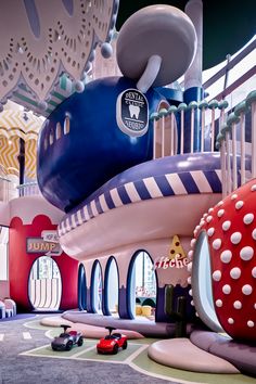 an inflatable playground with cars and toys on the ground, surrounded by colorful walls