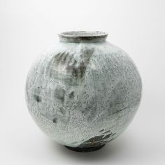 a large gray vase sitting on top of a white table