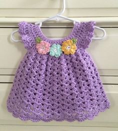 a purple crocheted dress hanging on a hook