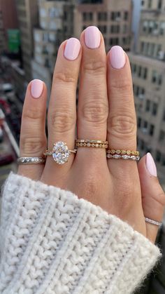 a woman's hand with three different rings on top of her fingers and the other half