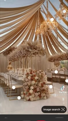 an image of a table setting with flowers and chandelier hanging from the ceiling