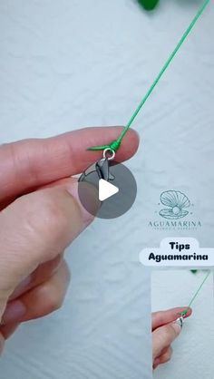 a person is holding a green string with a tag on it that says tips aguemarrina