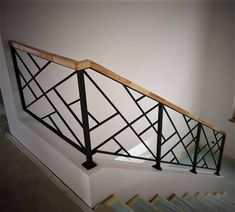 an iron and wood stair railing on a white wall