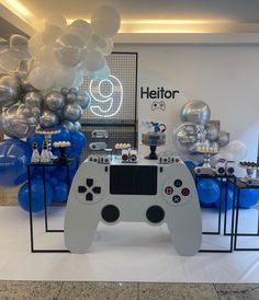 a video game controller is on display in front of balloons and balloons for the event