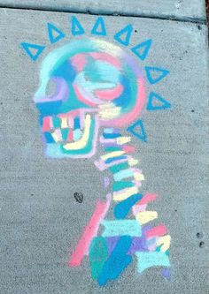 the sidewalk has been decorated with colorful chalk drawings and is marked with an image of a human head