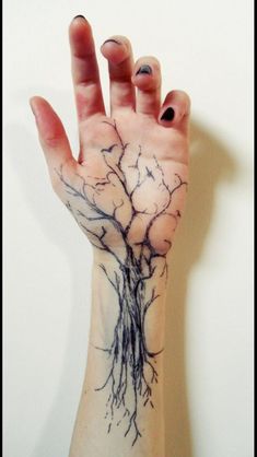 a person's hand with a tree tattoo on it