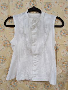 Early 1900s Corset Cover but can also be worn as a blouse. Pleated button front sleeveless blouse 100% Cotton.  Crocheted trim. Bust 28", waist 26" x length 20".  Please note 1 stain on back collar last picture Victorian Fitted Tops For Summer, Fitted Victorian Tops For Summer, Fitted Victorian Summer Tops, Classic Fitted Sleeveless Blouse, Fitted Sleeveless Blouse With Button Closure, Victorian Cotton Tops For Summer, Classic Sleeveless Buttoned Blouse, Classic Sleeveless Blouse With Buttons, Elegant Sleeveless Blouse With Buttons