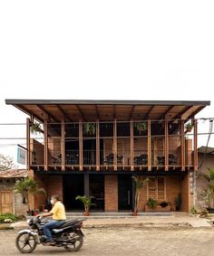 a person riding a motorcycle in front of a building