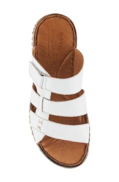 An adjustable instep strap offers a customized fit on a leather slide sandal grounded by a cushioned footbed for lasting comfort. 1" heel Adjustable strap with hook-and-loop closure Cushioned footbed Leather upper and lining/synthetic sole Made in Turkey White Slip-on Footbed Sandals With Arch Support, Comfortable White Slippers With Leather Footbed, White Open Toe Footbed Sandals With Ortholite Insole, White Leather Slippers With Cushioned Footbed, Comfortable White Leather Sandals, White Slide Sandals With Leather Footbed, White Adjustable Sandals With Ortholite Insole, White Leather Slide Footbed Sandals, White Leather Slippers With Removable Insole