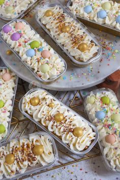 several trays filled with cake covered in frosting and sprinkles on top of a table