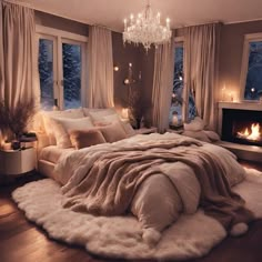 a large bed sitting in a bedroom under a chandelier next to a fire place