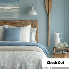 a bedroom with blue walls and white bedding