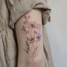 a woman's arm with flowers and leaves on the left side of her body