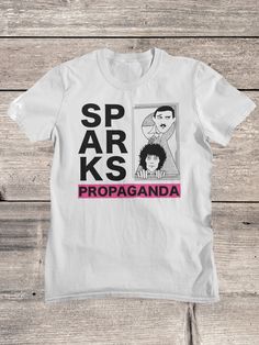 Sparks T-Shirt | Sparks Band Shirt | Glam Rock Shirt | Synth Pop  Sparks (formerly Halfnelson) is an American pop and rock duo formed by brothers Ron (keyboards) and Russell Mael (vocals) in Los Angeles. Our Shirts, hoodies and tanks have been carefully chosen after many years of testing, they are semi fitted around the chest and arms, and therefore give a complimentary look, but they also come in a nice length, Our shirts can be washed many times and the print will not fade, so you can enjoy yo White Rock Style Top For Concerts, White Crew Neck Rock Style Tops, Rock Style White Screen Print Tops, Rock Style White Top With Screen Print, White Rock Style Top With Screen Print, White Rock Style T-shirt For Streetwear, White Short Sleeve Shirt With Band Logo, White Punk Style Shirt With Screen Print, White Punk Style Pre-shrunk T-shirt