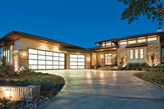 a large house that is lit up at night with lights on the front and side windows