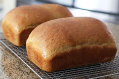 two loaves of bread sitting on a cooling rack